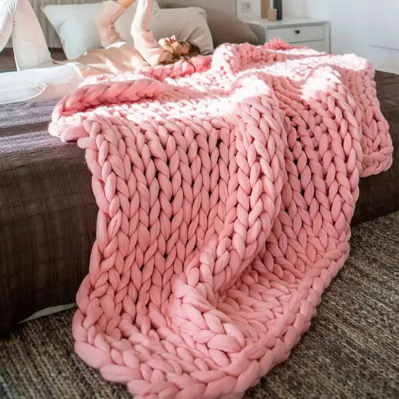 Pink chunky knit blanket on bed