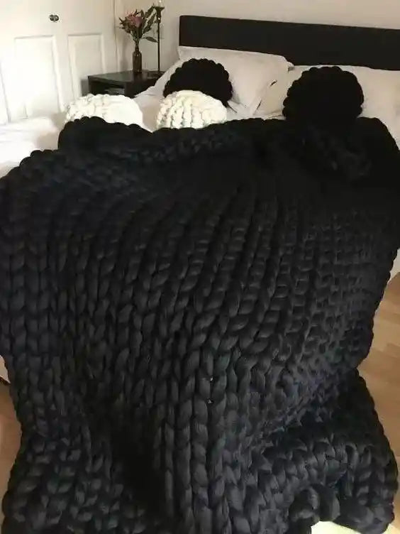 Black chunky knit blanket on bed