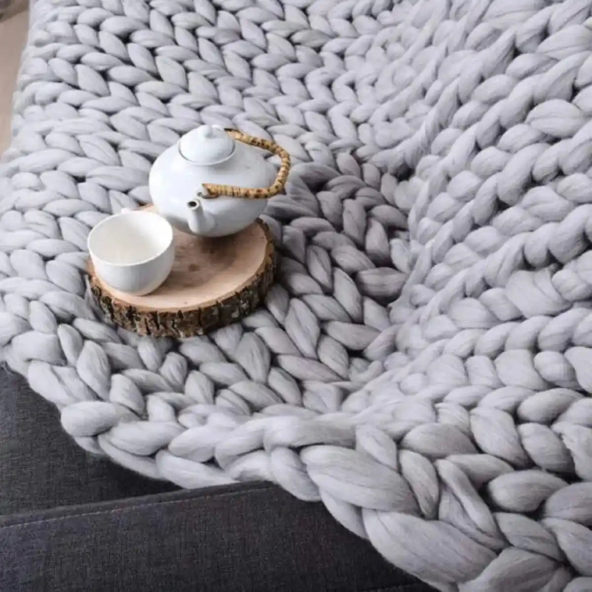 Gray chunky knit blanket with teapot and cup