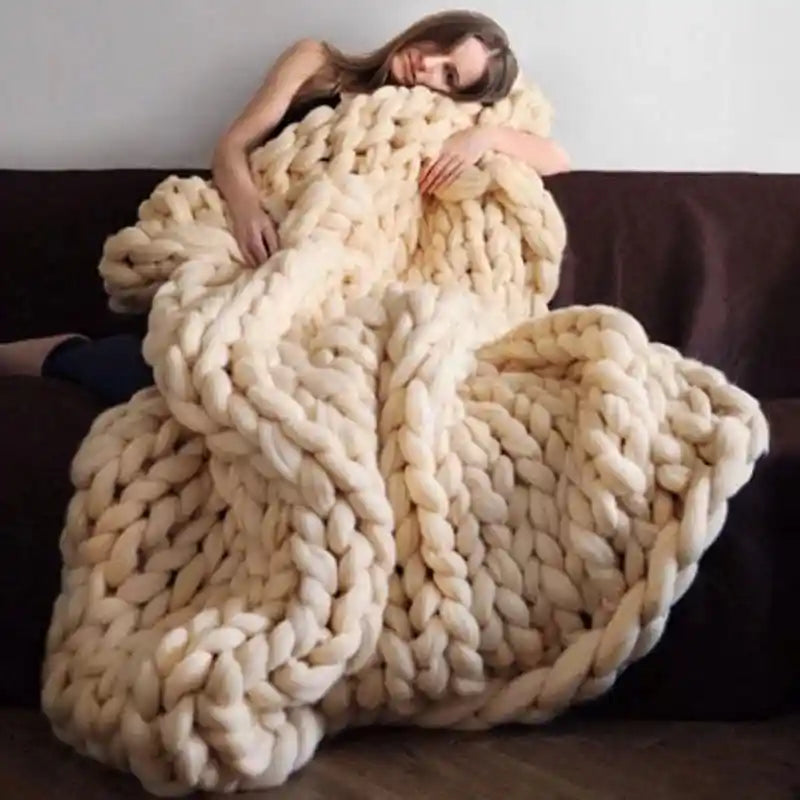 Cream chunky knit blanket on couch with person resting