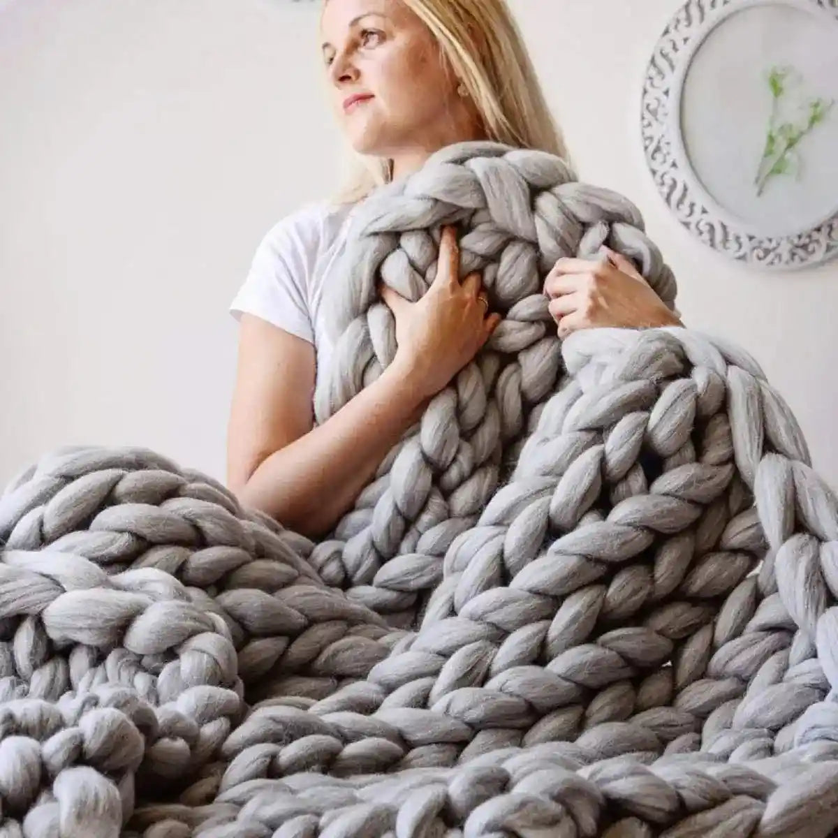 Gray chunky knit blanket held by person